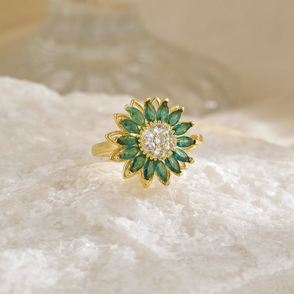 Top view of Solis anti-tarnish sunflower ring with green crystal petals on white raw stone