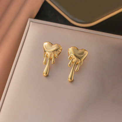 Celeste 18K gold plated melting heart earrings displayed on a beige jewelry box