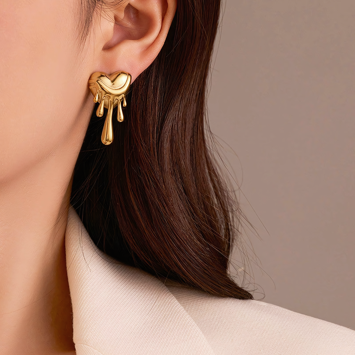 Side profile of a model wearing the lightweight Celeste 18K gold melting heart statement earring