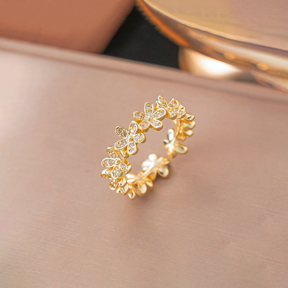 Fleur gold plated anti-tarnish floral ring standing on a smooth blush pink surface