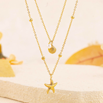 Close up of the Marina anti-tarnish gold layered satellite chain featuring detailed starfish and shell charms