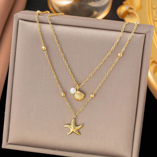Marina anti-tarnish gold starfish and shell layered necklace resting inside a premium jewelry gift box