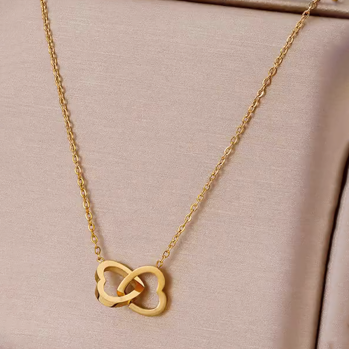 Detailed view of the smooth interlocking open heart design on the Nova gold anti-tarnish necklace